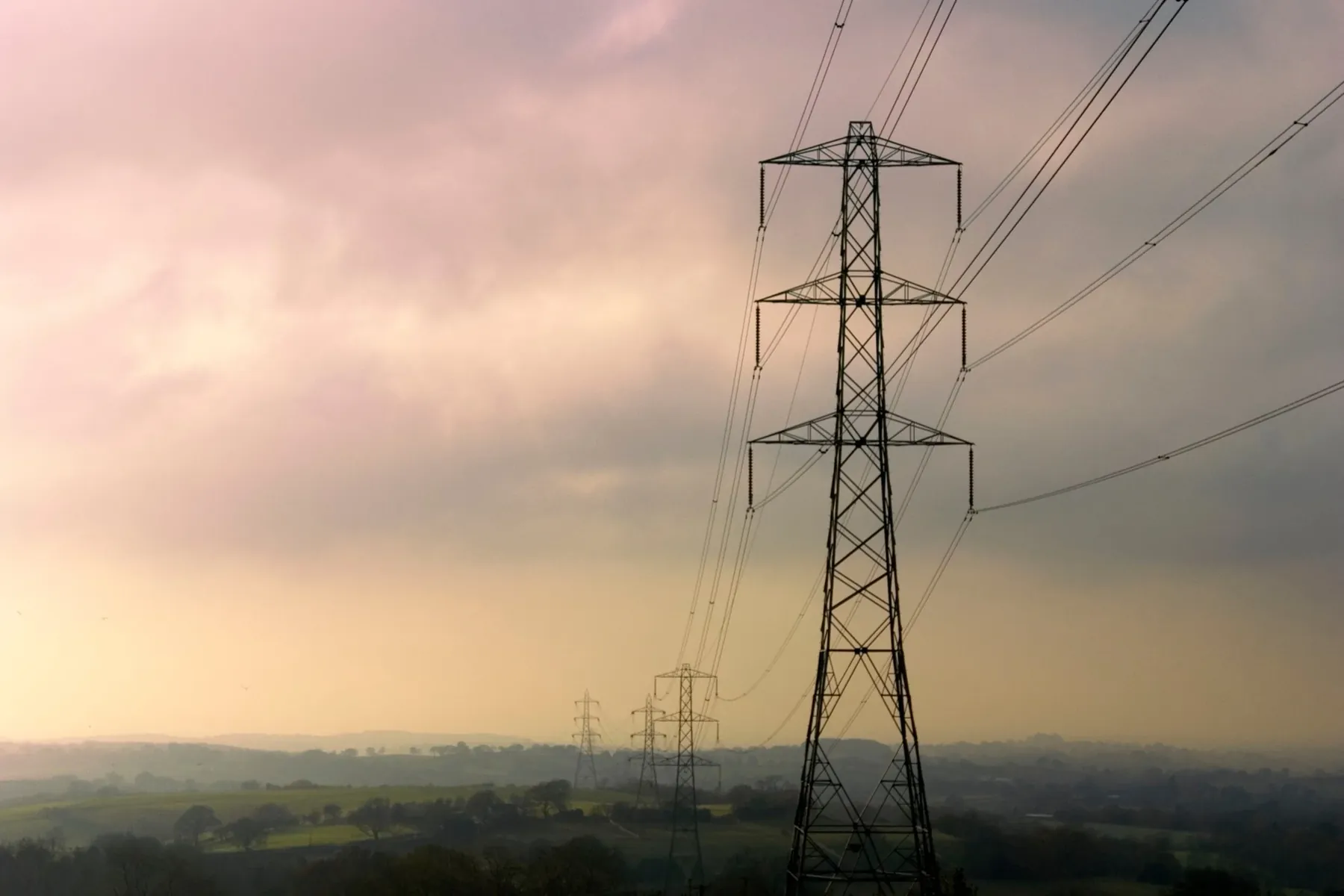 Pylons crossing the countryside at dusk